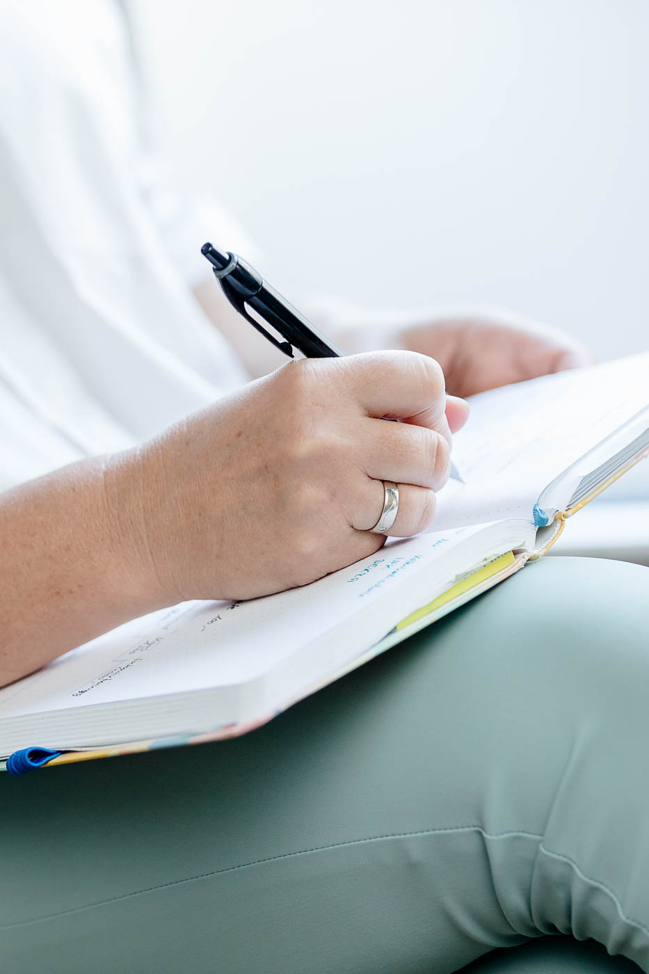 Hand mit Stift über einem Notizbuch
